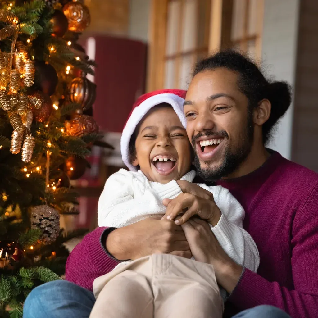 A father and child decorating a Christmas tree together